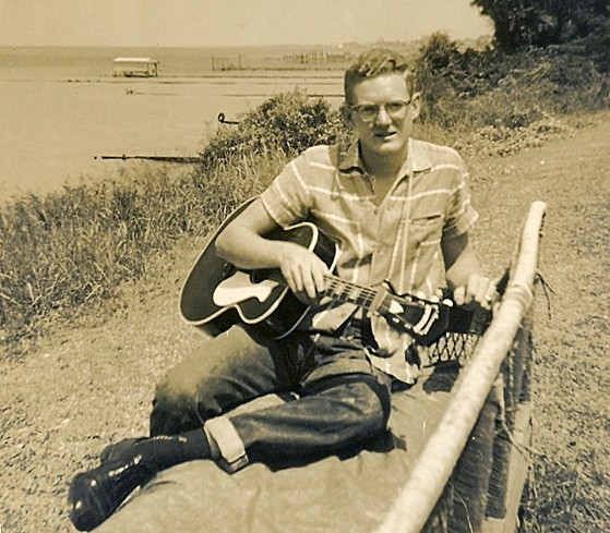 with guitar on banks of Galveston Bay